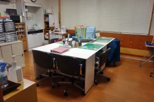 介護施設のレク室・創作活動スペース。テーブルと製作物が見える